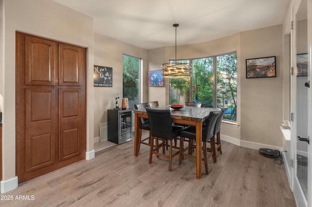 8447 W Tether Trl, Peoria, AZ 85383 - dining room with light wood finished floors, a chandelier, and wine cooler