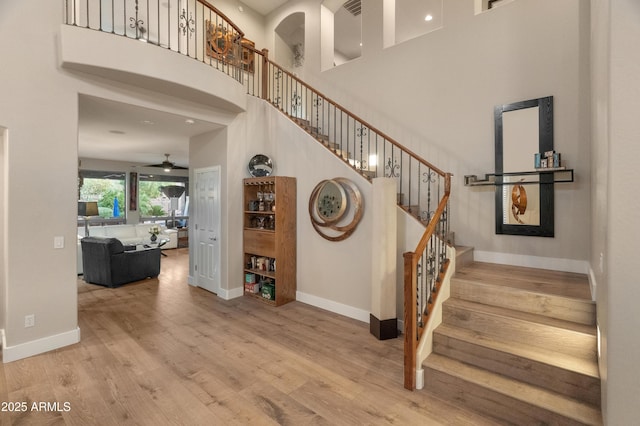 8447 W Tether Trl, Peoria, AZ 85383 - stairs featuring a towering ceiling, a ceiling fan, and wood finished floors