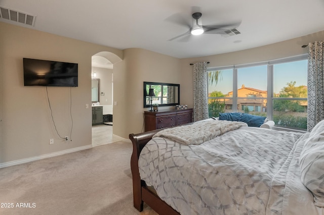 8447 W Tether Trl, Peoria, AZ 85383 - bedroom featuring arched walkways, light colored carpet, ensuite bath, and ceiling fan