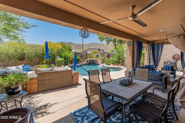 8447 W Tether Trl, Peoria, AZ 85383 - fenced backyard featuring an outdoor hangout area, a mountain view, a patio, ceiling fan, and outdoor dining space