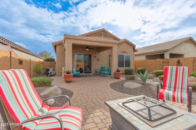 back of property featuring ceiling fan and a patio