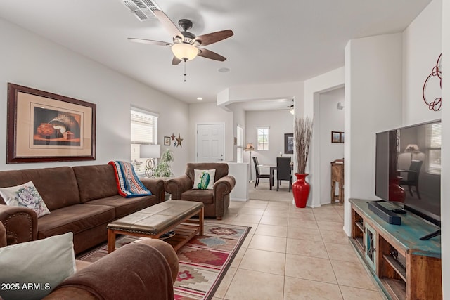 tiled living room with a wealth of natural light and ceiling fan