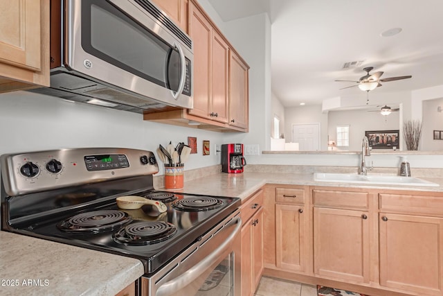 kitchen with sink, light tile patterned floors, ceiling fan, stainless steel appliances, and light brown cabinets