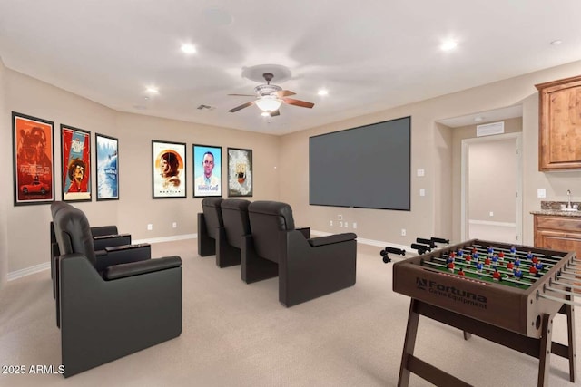 carpeted home theater with ceiling fan