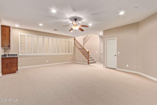 interior space with ceiling fan and light colored carpet