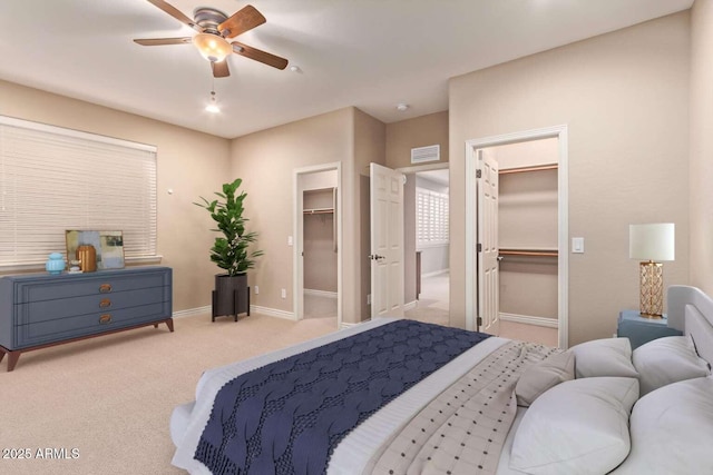 carpeted bedroom with ceiling fan and a spacious closet