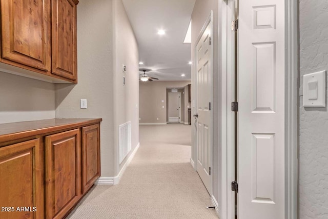 hall featuring light colored carpet