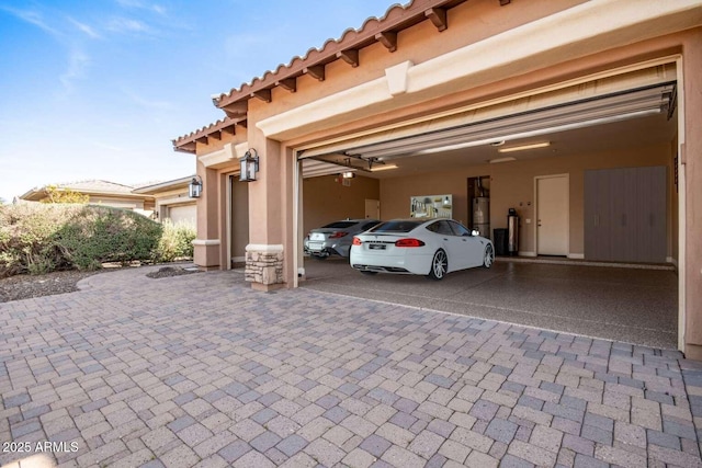 view of car parking featuring a garage and gas water heater