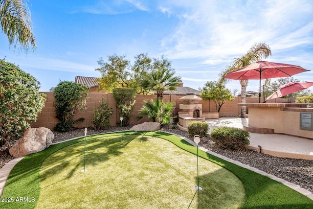 view of yard featuring an outdoor fireplace and a patio