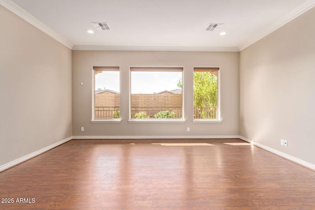 unfurnished room with wood-type flooring, a wealth of natural light, and ornamental molding