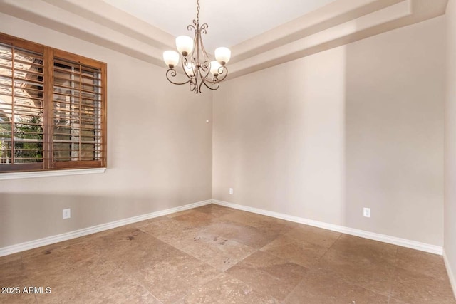 unfurnished room with a notable chandelier and a tray ceiling