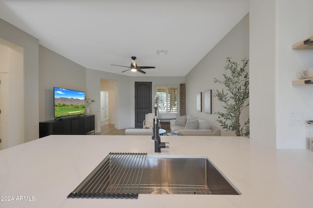 kitchen featuring wood-type flooring, ceiling fan, and sink