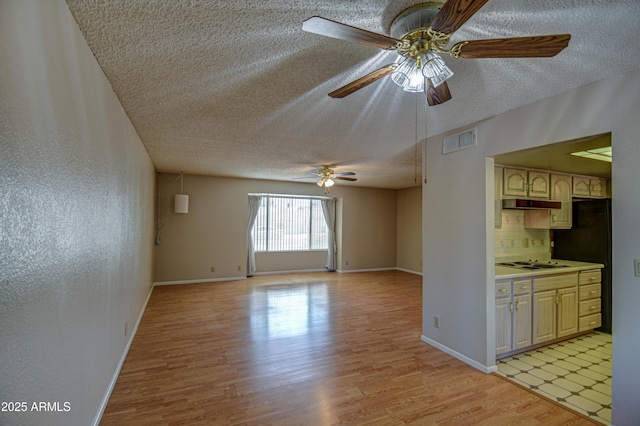 interior space with ceiling fan, a textured ceiling, and light hardwood / wood-style flooring