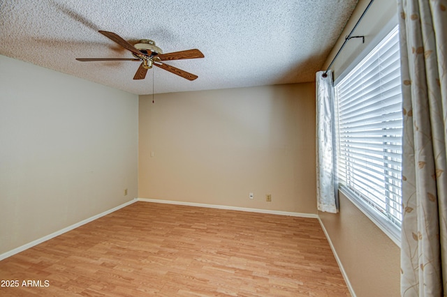 empty room with ceiling fan, a textured ceiling, and light wood-type flooring