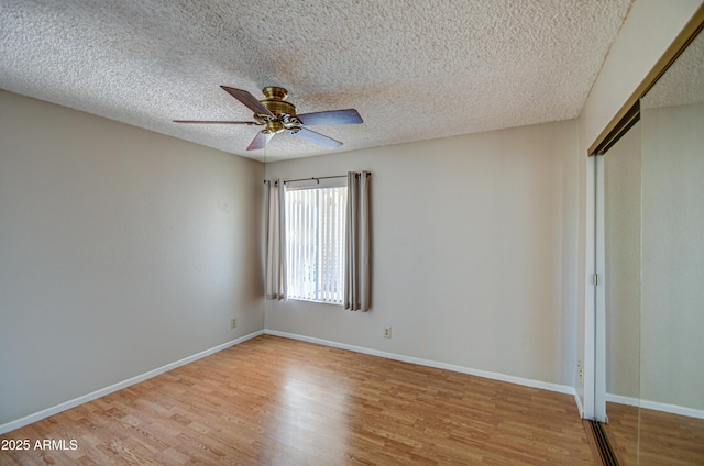 unfurnished bedroom with ceiling fan, a closet, a textured ceiling, and light wood-type flooring