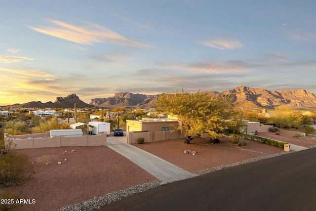 view of front of house with a fenced front yard, a gate, a mountain view, and driveway