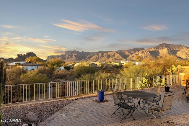 view of patio / terrace featuring fence, a mountain view, and outdoor dining space