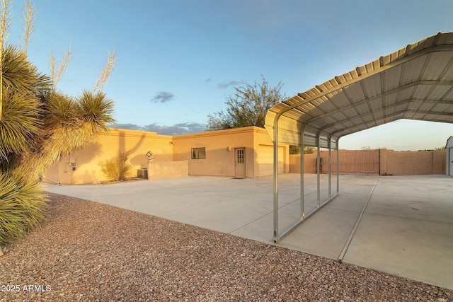 view of patio / terrace featuring a carport, fence, and driveway