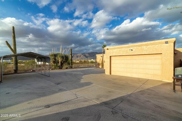 exterior space featuring a mountain view, a carport, and stucco siding