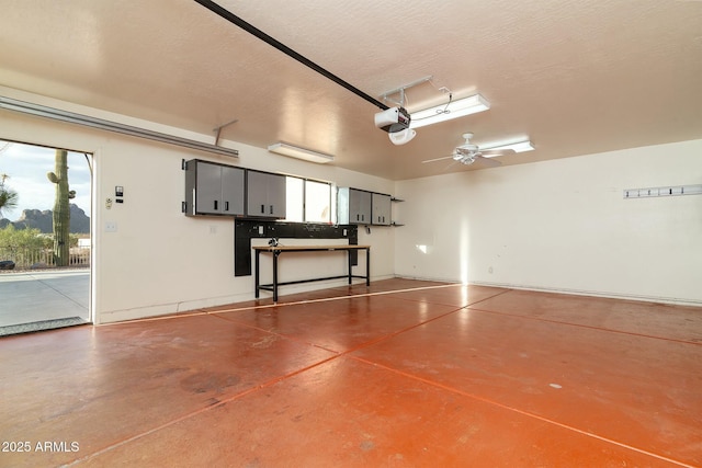 garage with a garage door opener and ceiling fan