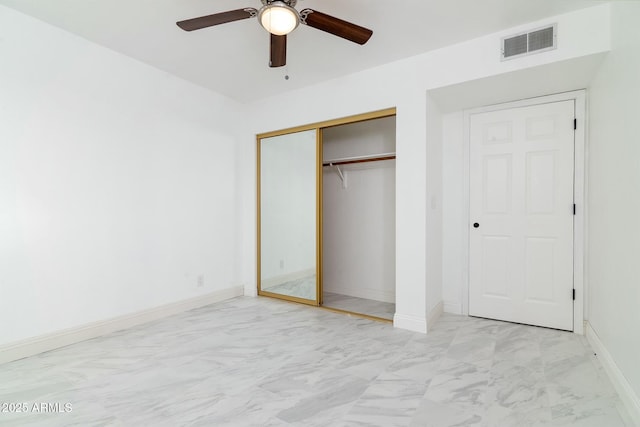 unfurnished bedroom with a closet, marble finish floor, visible vents, and baseboards