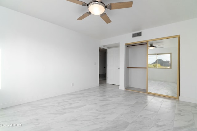 unfurnished bedroom with marble finish floor, a closet, visible vents, a ceiling fan, and baseboards