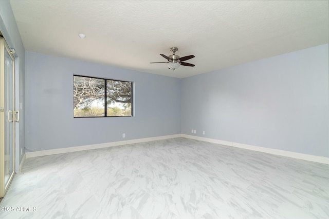 empty room featuring ceiling fan, a textured ceiling, and baseboards