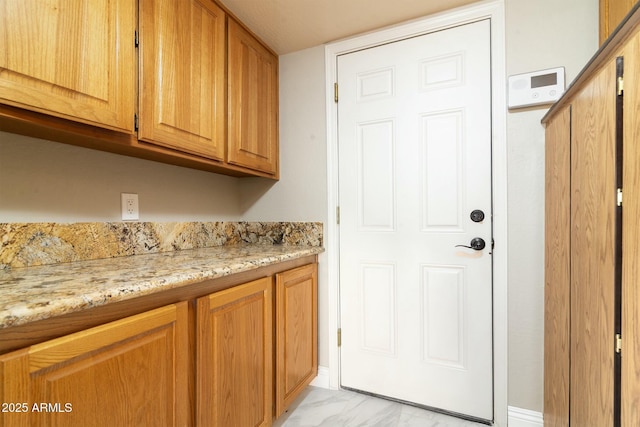 clothes washing area with marble finish floor