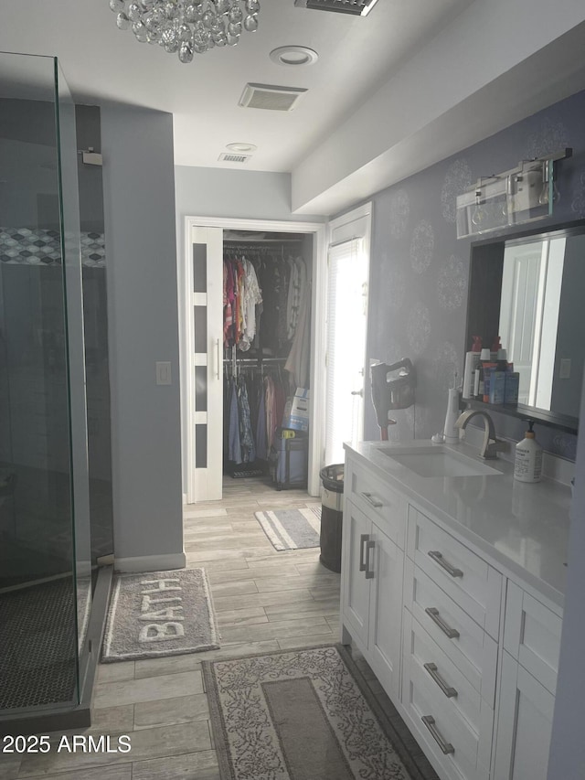 bathroom with a shower with door and vanity