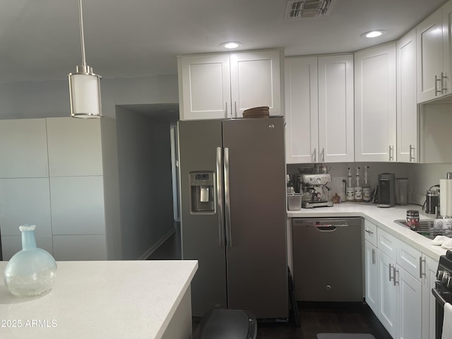 kitchen with hanging light fixtures, stainless steel appliances, and white cabinets