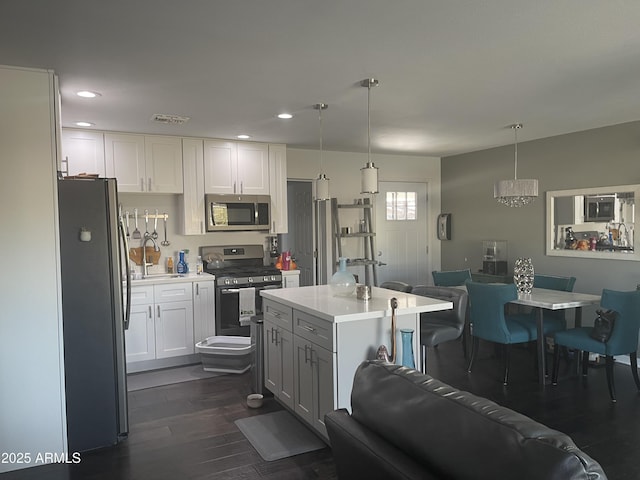 kitchen with white cabinetry, appliances with stainless steel finishes, sink, and pendant lighting