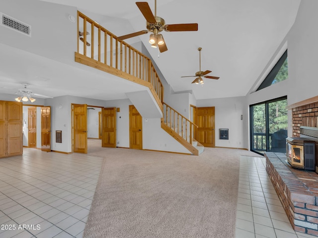 5130 Juniper Loop, Pine, AZ 85544 - unfurnished living room with high vaulted ceiling, a ceiling fan, stairs, a wood stove, and light tile patterned flooring