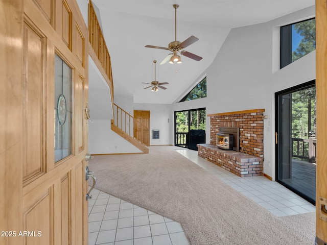 5130 Juniper Loop, Pine, AZ 85544 - unfurnished living room featuring light tile patterned flooring, high vaulted ceiling, a ceiling fan, stairway, and light carpet