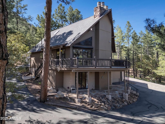 5130 Juniper Loop, Pine, AZ 85544 - view of front of home featuring concrete driveway, a chimney, a wooden deck, a shingled roof, and an attached garage