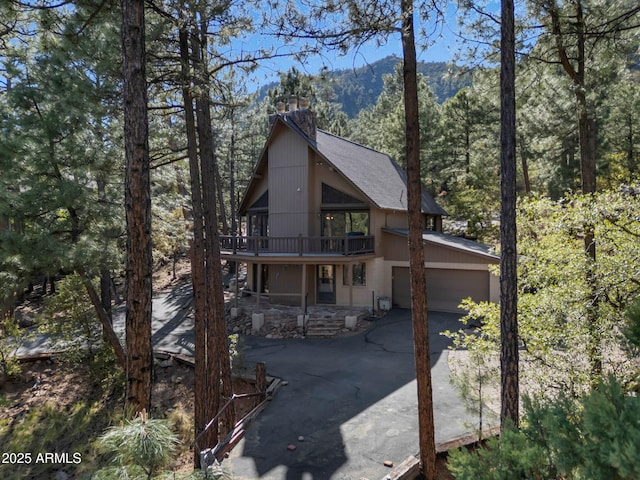 5130 Juniper Loop, Pine, AZ 85544 - rustic home with asphalt driveway, a chimney, a deck with mountain view, a forest view, and a shingled roof