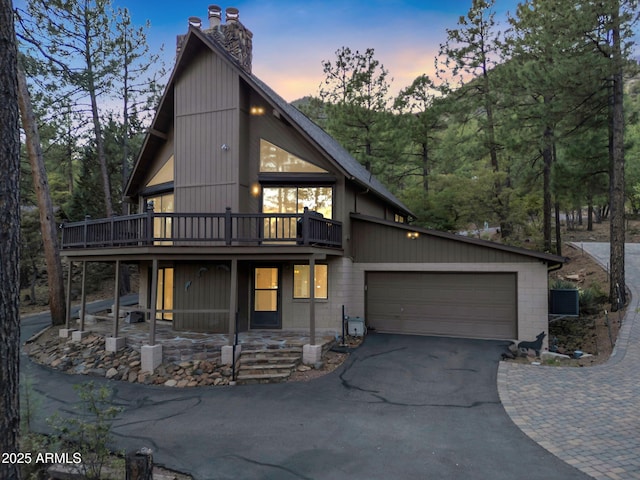 5130 Juniper Loop, Pine, AZ 85544 - view of front facade with asphalt driveway, a chimney, an attached garage, and a deck