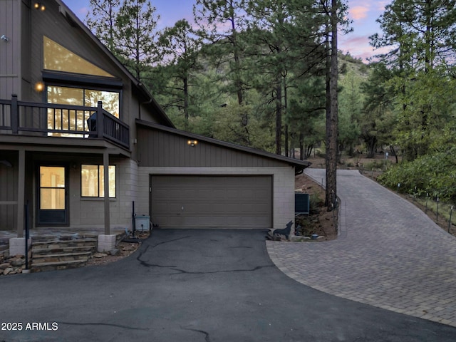5130 Juniper Loop, Pine, AZ 85544 - property exterior at dusk with asphalt driveway, an attached garage, concrete block siding, and a balcony