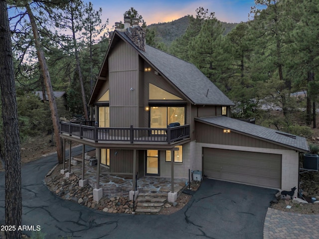 5130 Juniper Loop, Pine, AZ 85544 - chalet / cabin with roof with shingles, driveway, a chimney, central air condition unit, and a wooden deck