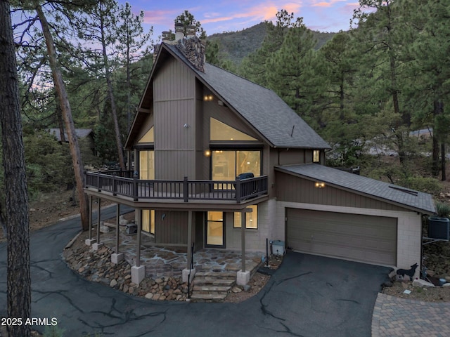 5130 Juniper Loop, Pine, AZ 85544 - view of front of house featuring a shingled roof, a chimney, driveway, central AC unit, and a wooden deck