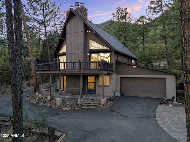 5130 Juniper Loop, Pine, AZ 85544 - view of front of home with a chimney, asphalt driveway, a deck, a garage, and a view of trees