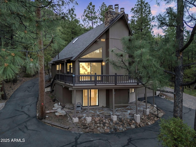 5130 Juniper Loop, Pine, AZ 85544 - view of front facade with driveway, a shingled roof, a chimney, a deck, and a garage