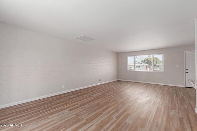 3812 W Seldon Ln, Phoenix, AZ 85051 - empty room featuring brick wall and light wood-style floors