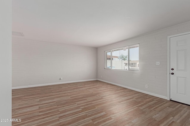 3812 W Seldon Ln, Phoenix, AZ 85051 - unfurnished room featuring brick wall and light wood finished floors