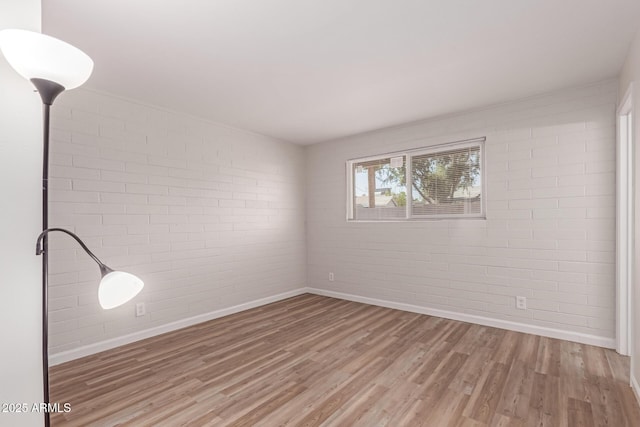 3812 W Seldon Ln, Phoenix, AZ 85051 - unfurnished room featuring brick wall and light wood-type flooring