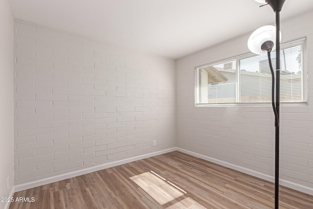 3812 W Seldon Ln, Phoenix, AZ 85051 - spare room with wood finished floors and brick wall