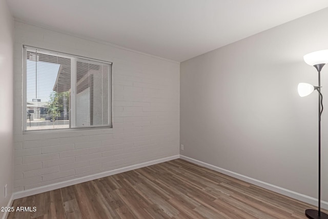 3812 W Seldon Ln, Phoenix, AZ 85051 - spare room with wood finished floors and brick wall