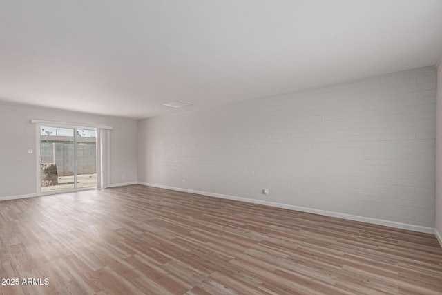 3812 W Seldon Ln, Phoenix, AZ 85051 - unfurnished room with brick wall and light wood-style floors