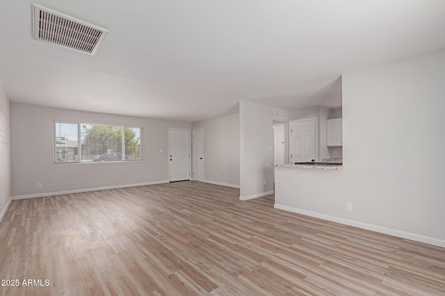 3812 W Seldon Ln, Phoenix, AZ 85051 - unfurnished living room featuring baseboards and light wood-style floors