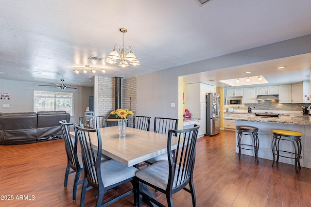 3408 W Carol Ave, Phoenix, AZ 85051 - dining room with dark wood-style flooring, visible vents, an inviting chandelier, and a wood stove