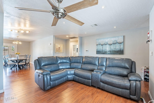 3408 W Carol Ave, Phoenix, AZ 85051 - living room with a textured ceiling, ceiling fan with notable chandelier, recessed lighting, wood finished floors, and visible vents